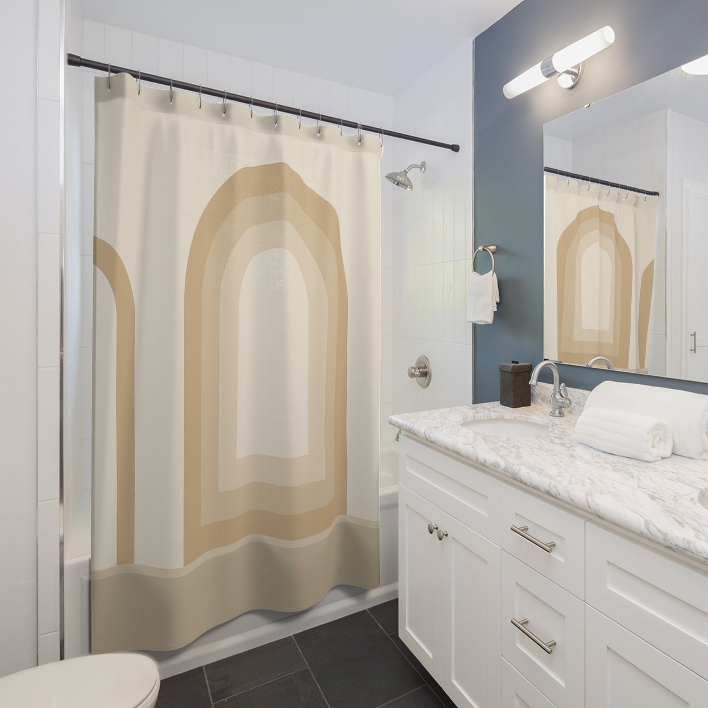 Bathroom with a shower curtain featuring arches, white vanity, and mirror.