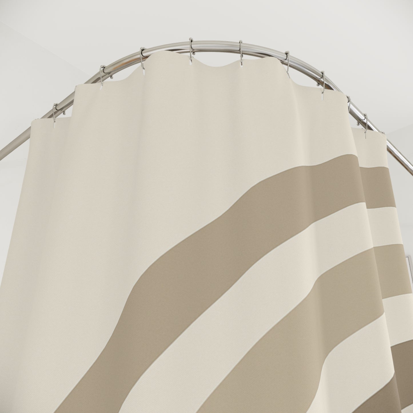 Beige and brown striped shower curtain on a silver rod against a white background
