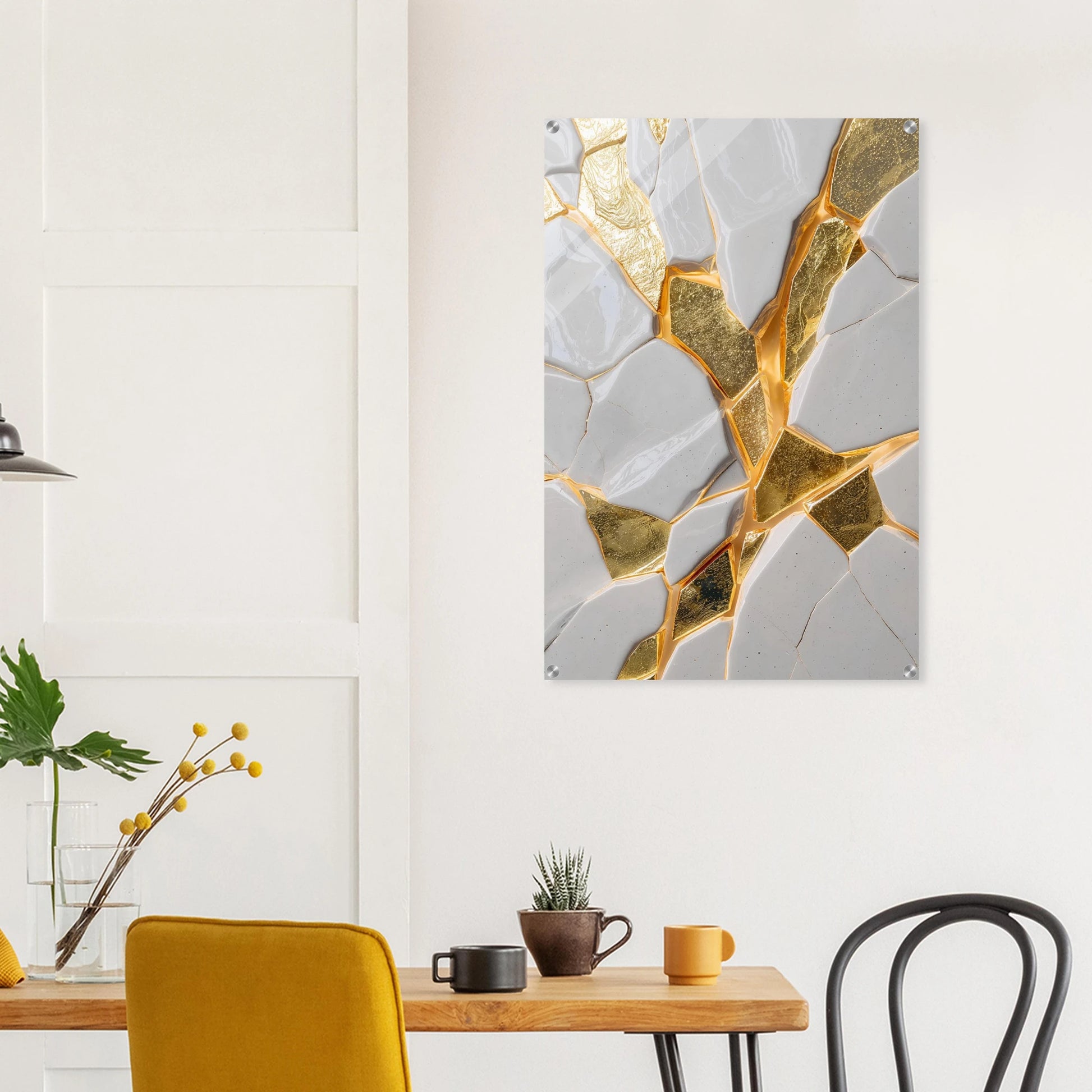 Abstract art piece with gold and gray design on a wall above a dining table.