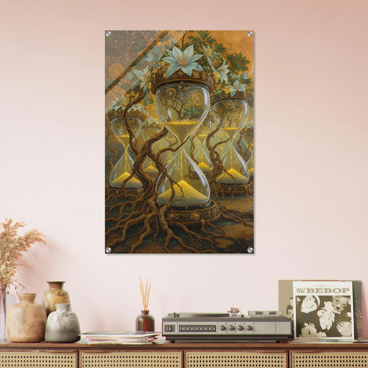 Framed artwork of hourglass design with roots on a pink wall above a wooden shelf.