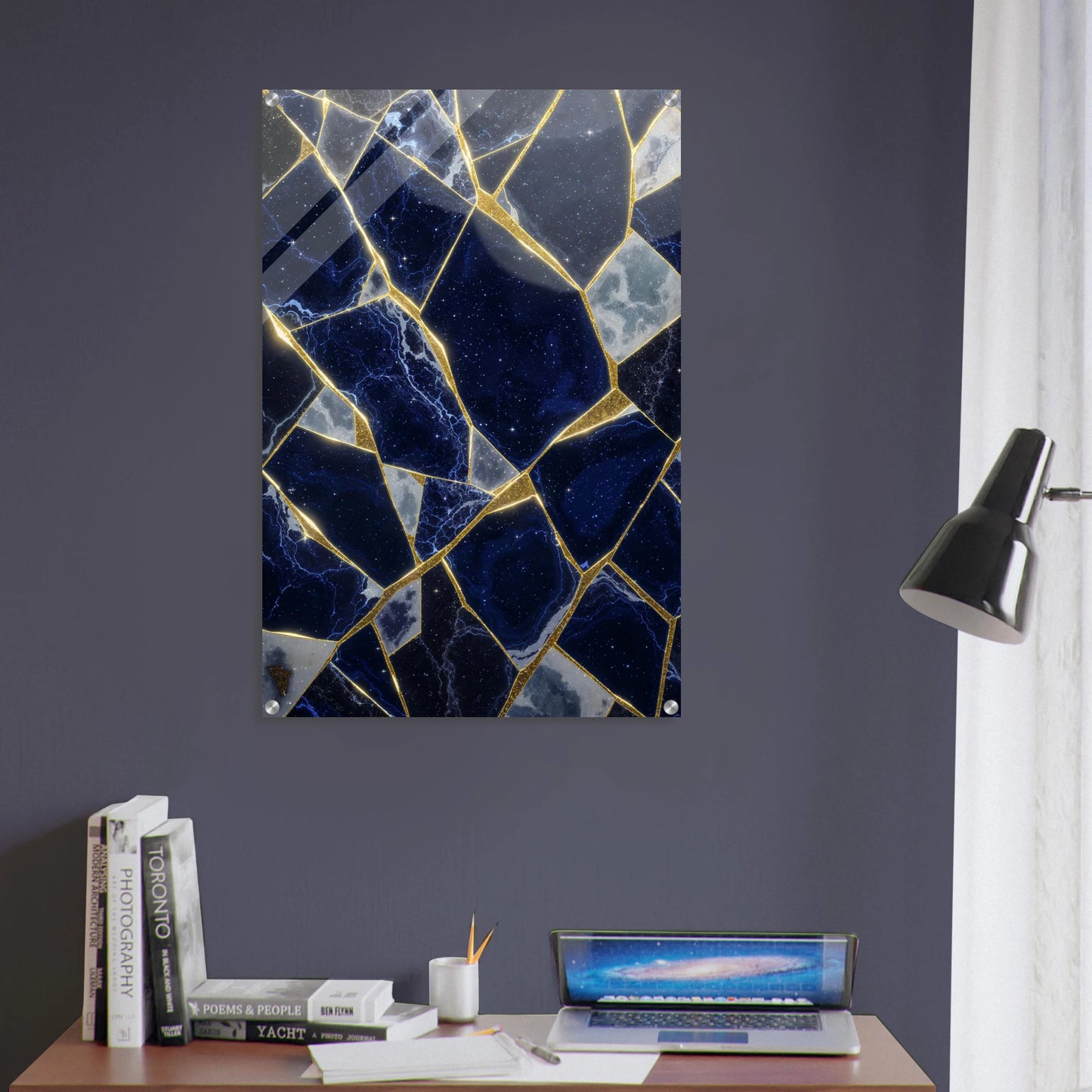 Marble-patterned wall art on a dark gray wall with books and a laptop on a desk.
