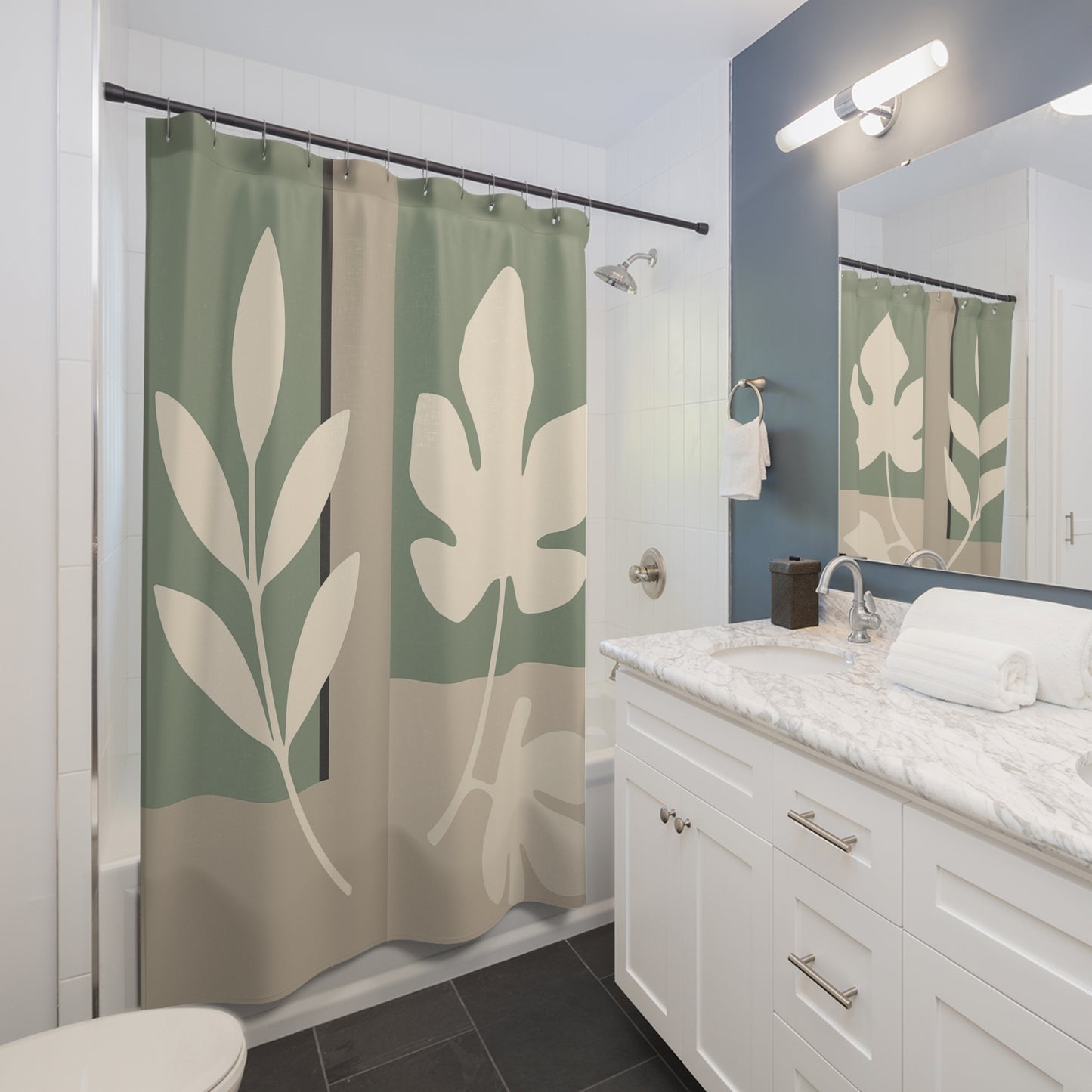 Bathroom with a leaf-patterned shower curtain and white vanity.