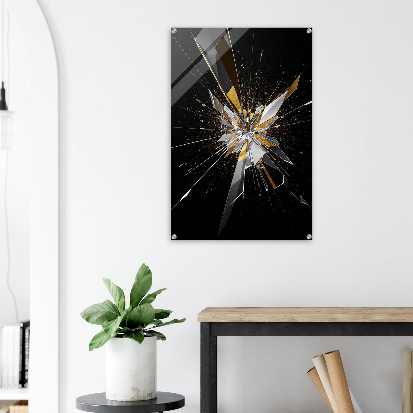 Abstract art piece with a shattered glass design on a black background, mounted on a white wall above a wooden desk.