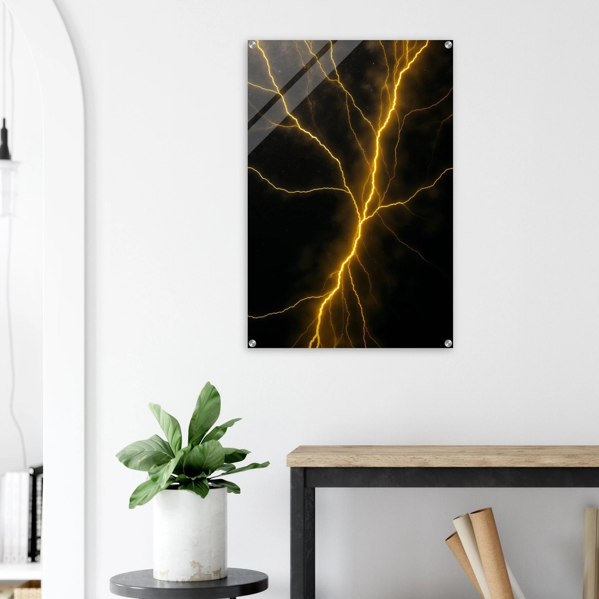 Abstract art piece of yellow lightning on a black background hanging on a white wall above a desk.