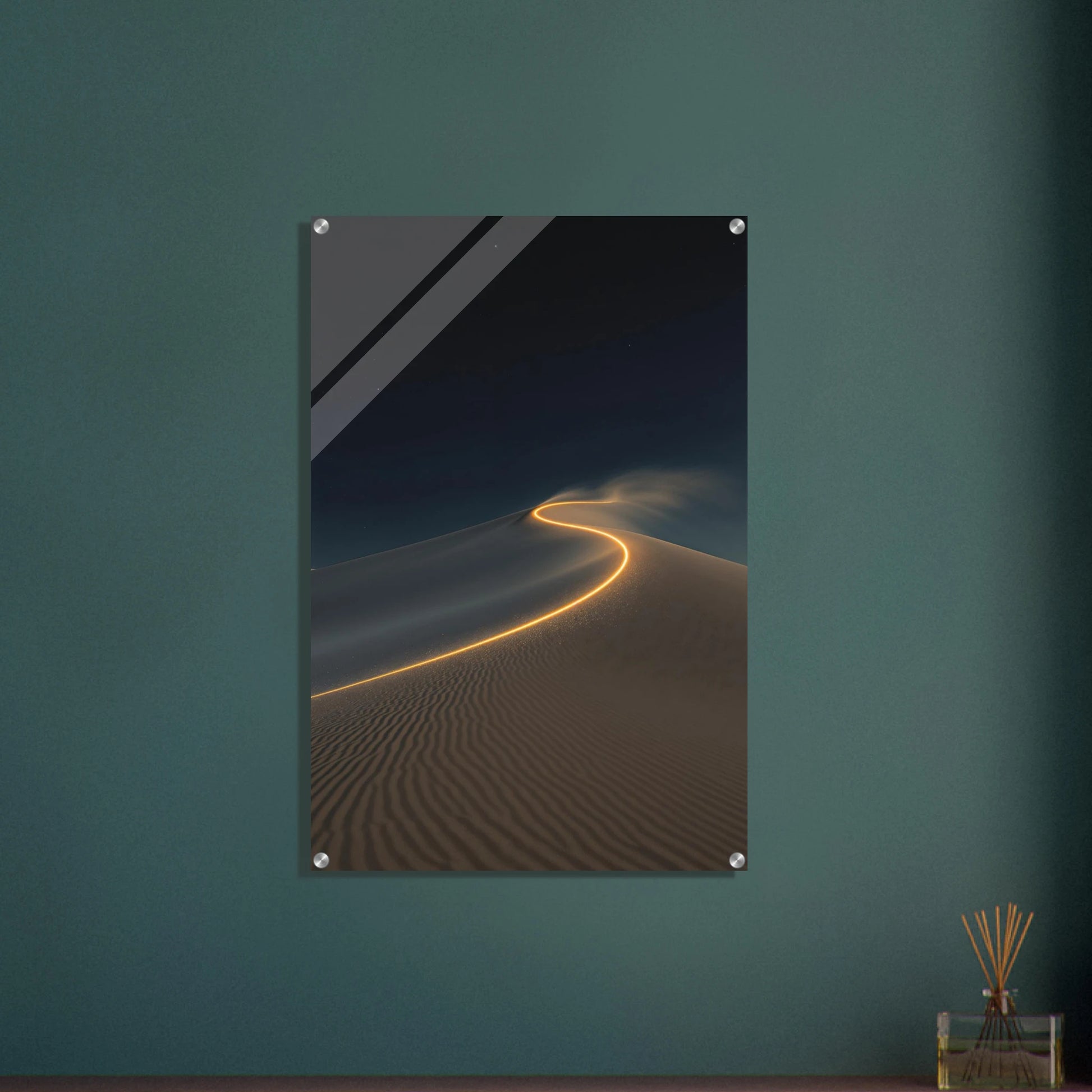 Framed artwork of a desert scene with a winding path on a teal wall.