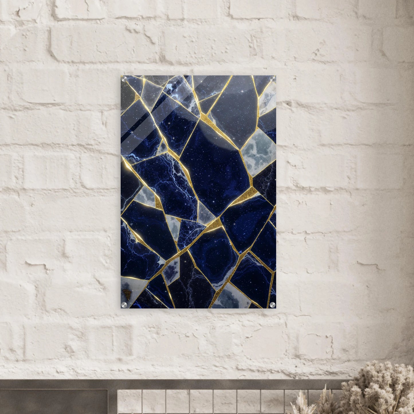 Decorative wall art with blue and gold mosaic pattern on a white brick wall.