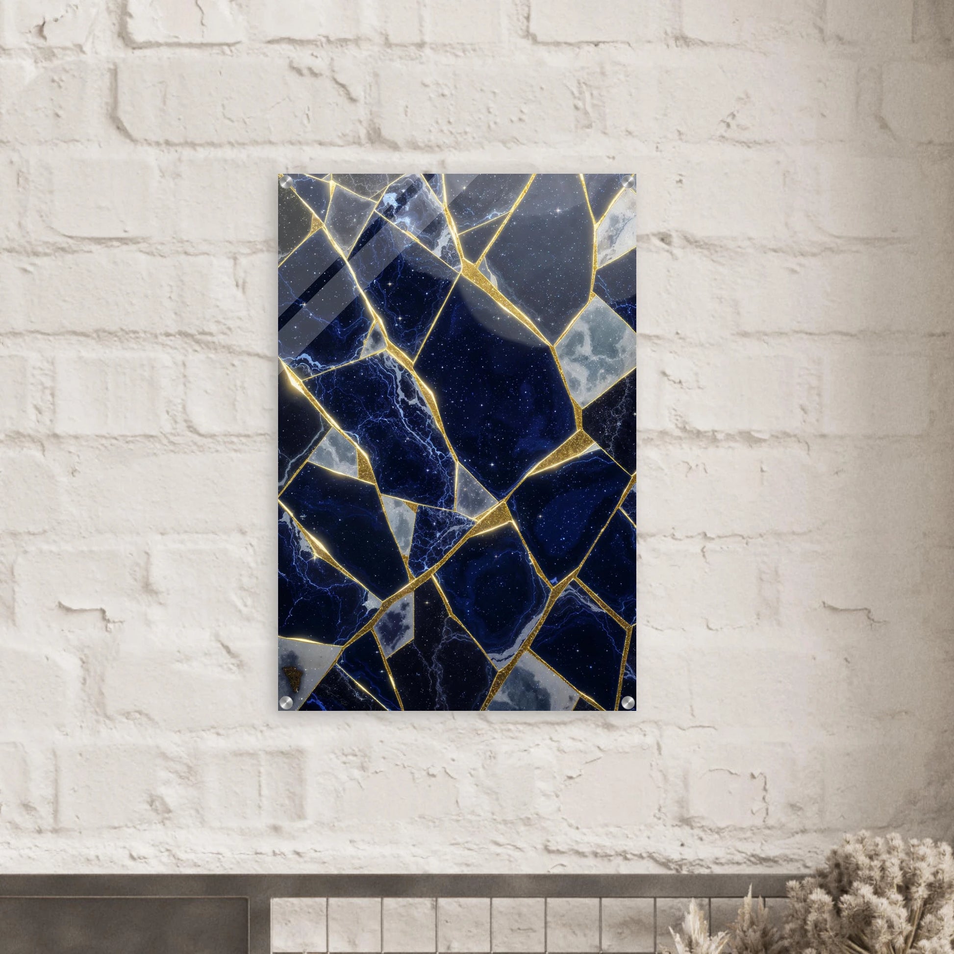 Decorative wall art with blue and gold mosaic pattern on a white brick wall.