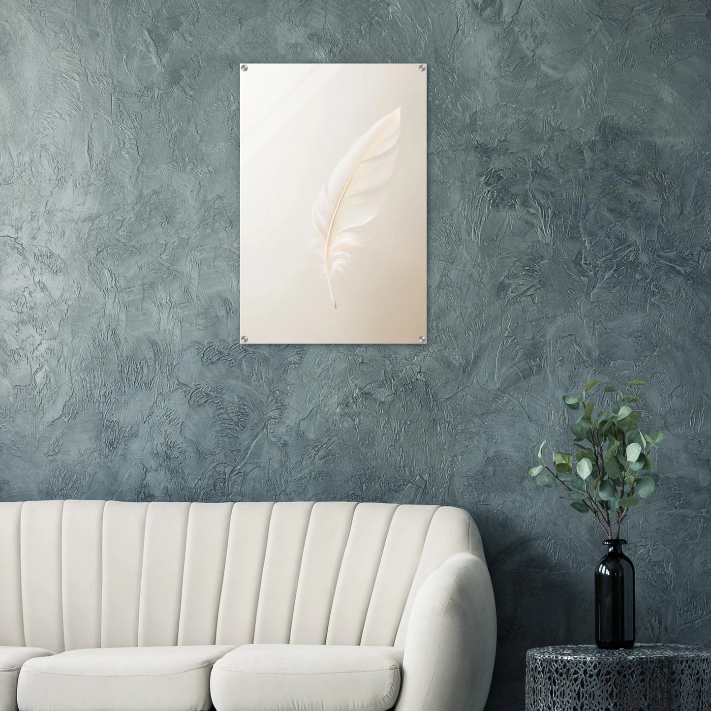 Decorative wall art with a feather design on a textured gray wall above a white sofa.