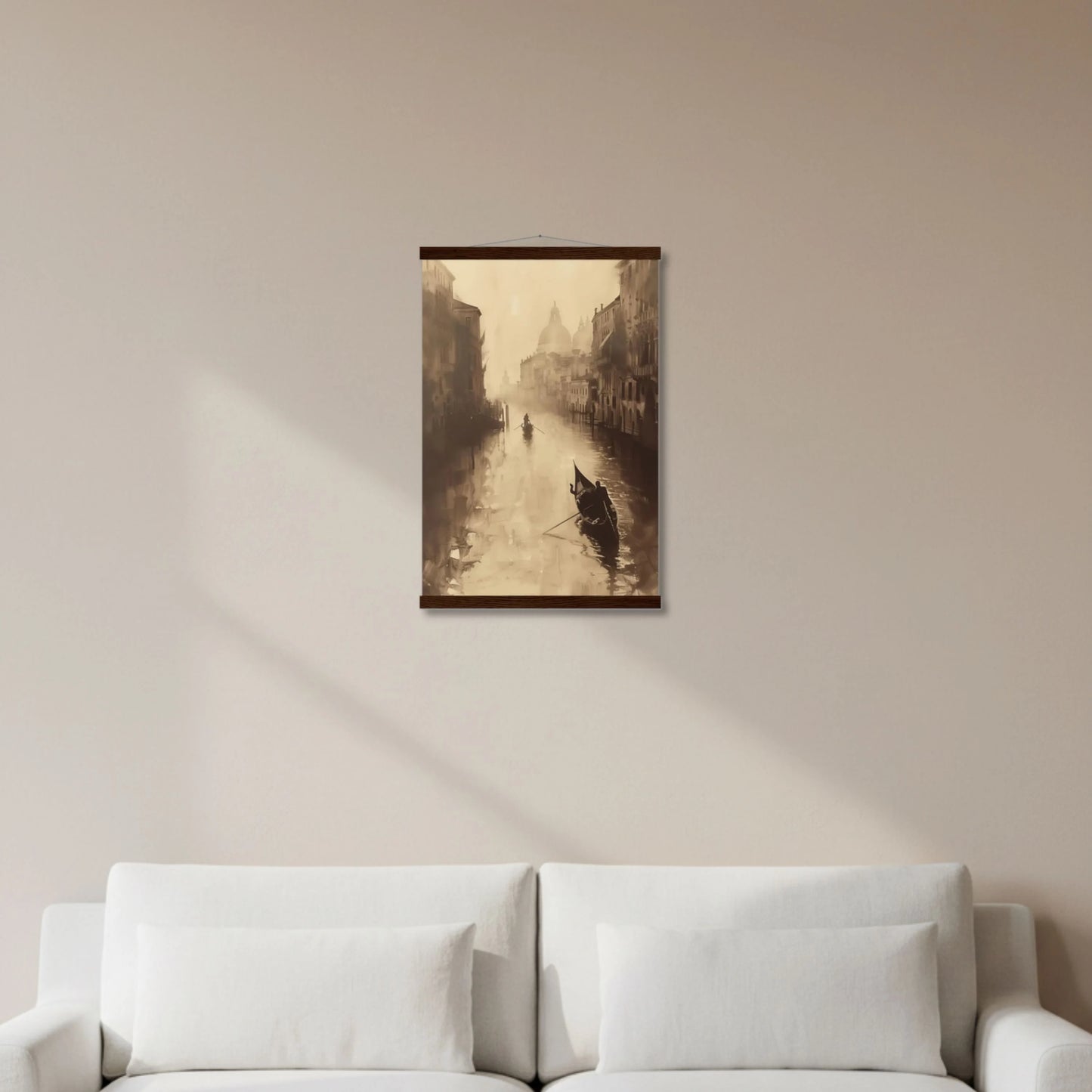 Framed artwork of a canal scene with gondola on a beige wall above a white sofa.