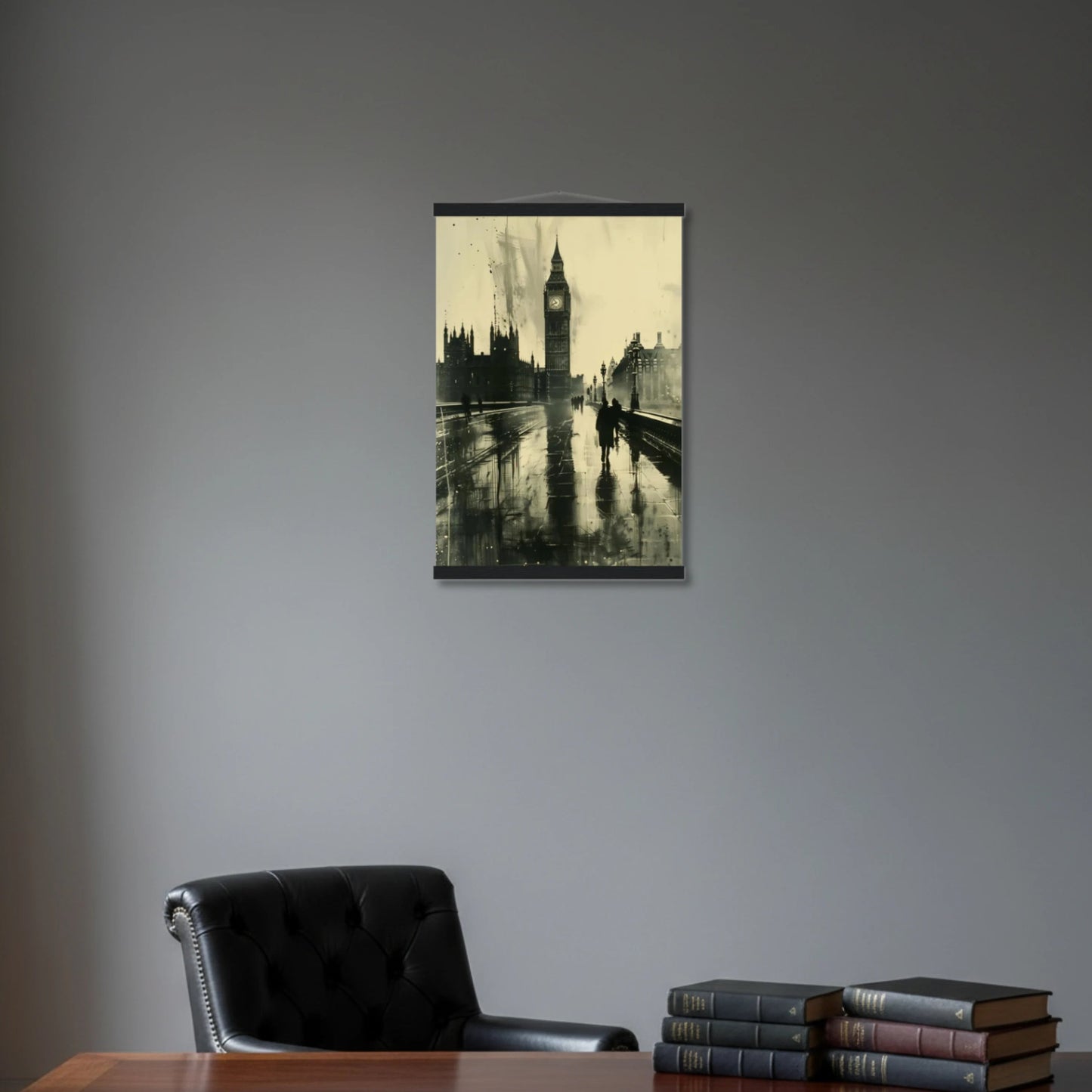 Framed artwork of a cityscape with a clock tower on a gray wall above a desk with books.